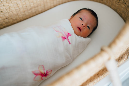 mom wrapping baby in swaddle coco moon