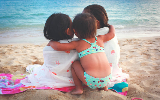 Girls on beach in Hawaii with Coco Moon swaddle blanket